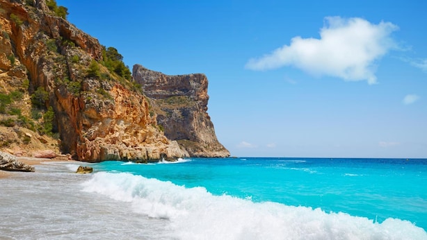 A coastal landscape with clear turquoise waters, rocky cliffs, and a sandy beach. - Villa Nora in El Poble Nou de Benitatxell (Benitachell)
