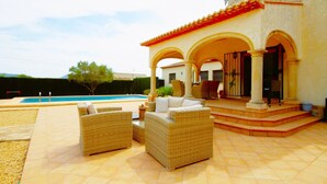 A house with a swimming pool, outdoor seating, and a covered patio area. - Fanila in J vea With 4 Bedrooms and 3 Bathrooms (Javea)