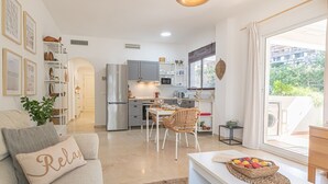 A compact living space with a kitchenette, dining area, and a sofa with a 'Relax' pillow. - Modern Riviera Golf Y Mar (Mijas)
