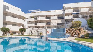 A modern hotel with a central swimming pool, multiple balconies, and a staircase leading to an upper level. - Modern Riviera Golf Y Mar (Mijas)