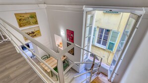 A staircase with a view of a dining area and artwork on the walls. - Two Levels Apt In Historical Building (Menton)