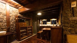 Una cocina rústica con armarios de madera, una pared de piedra y suelo de madera.
