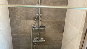 A shower with a handheld showerhead, a wall-mounted faucet, and a handheld showerhead. - Charming bright apartment with large living room and 2 bedrooms - Comfort guaranteed (Trévillach)