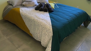 A room with a bed, pillows, a blanket, and a window with curtains. - Charming bright apartment with large living room and 2 bedrooms - Comfort guaranteed (Trévillach)