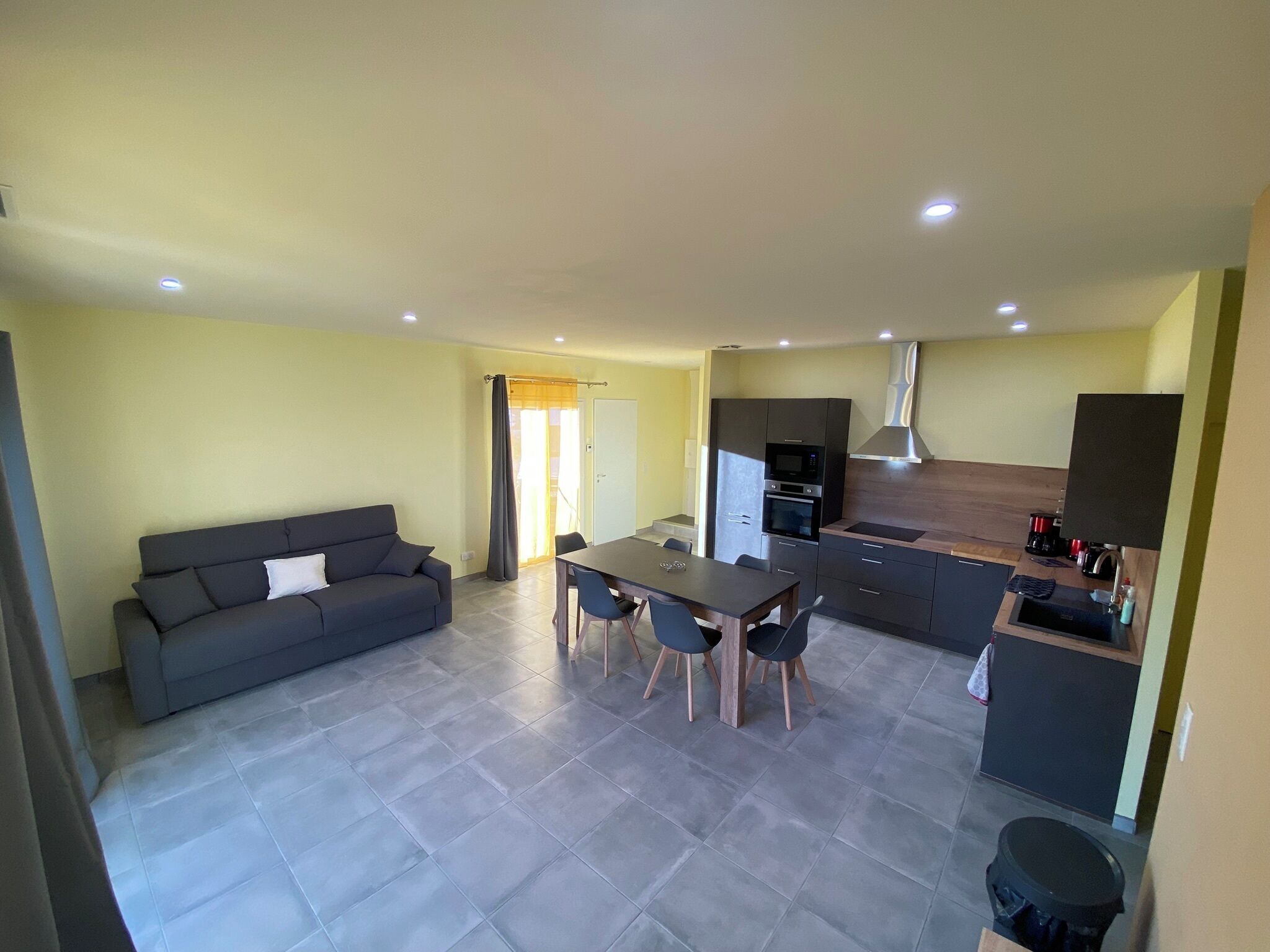 Eine moderne Wohnung mit Wohnbereich, Essbereich und Küche.