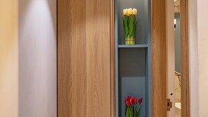 Een houten kast met twee planken, elk met een bos bloemen.