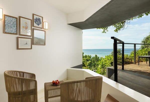 A balcony with wicker furniture, framed artwork, and a view of the sea. - Uga Prāva - Tangalle (Tangalle)