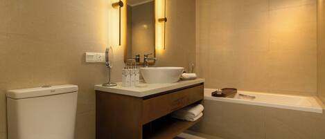 A modern bathroom with a large mirror, a white sink, and a bathtub.