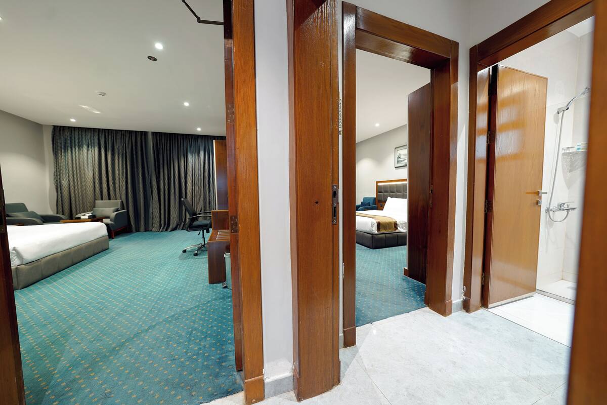 Een hotelkamer met een bed, een bureau, een stoel, een douche en een badkamer.