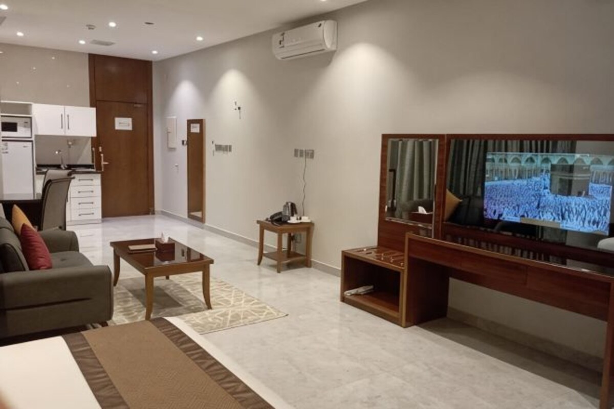 Una sala de estar moderna con una televisión de pantalla plana, un sofá, una mesa de centro y un mueble para la televisión.