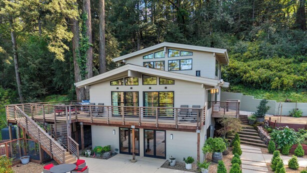 A modern two-story house with a deck, a pool, and a forested backdrop. - LUX Private Modern Villa | Pool, Spa, & Dogs OK (Calistoga)