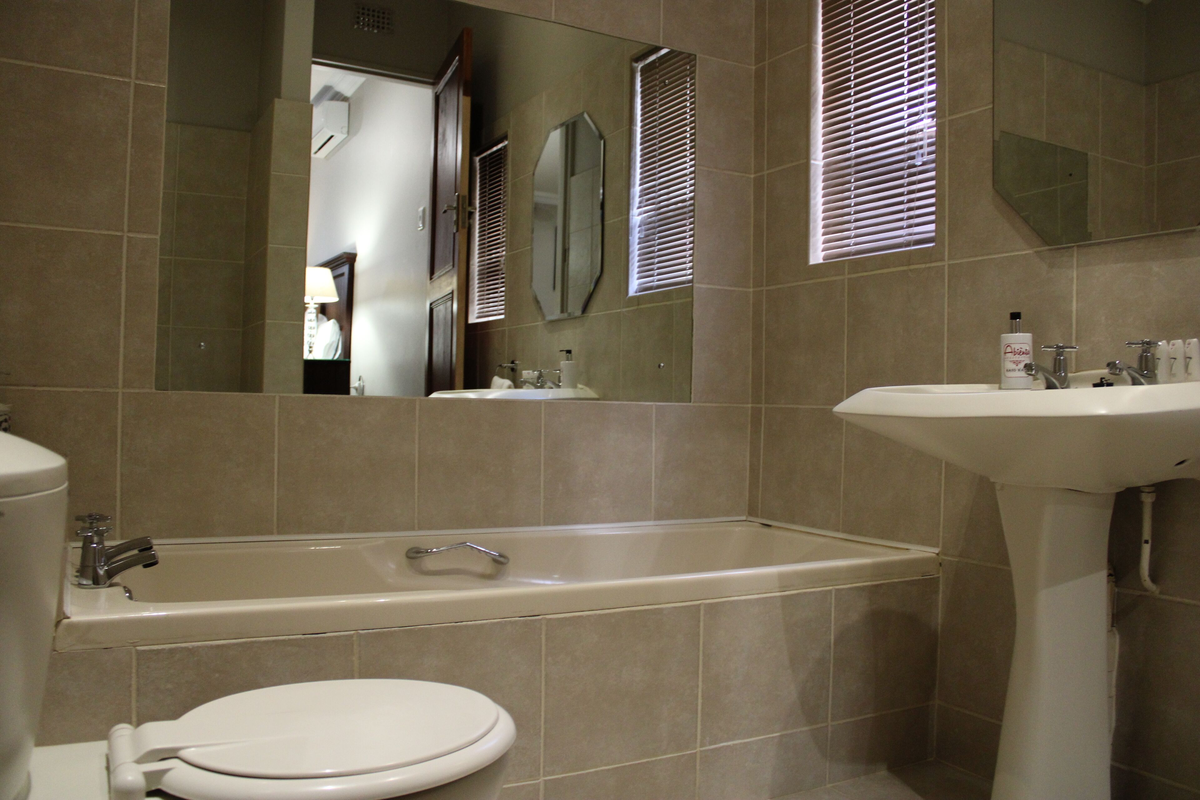 Une salle de bain équipée d’une baignoire, de toilettes, d’un lavabo et d’un miroir.