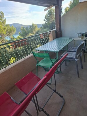 Ein Balkon mit Tisch und Stühlen und Blick auf die Landschaft, ausgestattet mit Geländer.