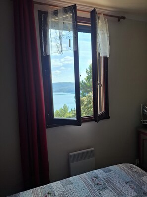 A room with a bed, a window with curtains, and a radiator. - 8 Le Castellas (Sainte-Croix-du-Verdon)