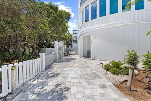 A paved pathway leading to a building with a white exterior and large windows. - 30A | Rooftop Pool | Gulf Views | 2 Min To Beach! (Santa Rosa Beach)
