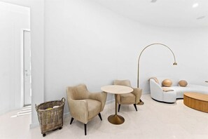 A modern living room with a sofa, two armchairs, a round table, a floor lamp, and a wicker basket. - 30A | Rooftop Pool | Gulf Views | 2 Min To Beach! (Santa Rosa Beach)
