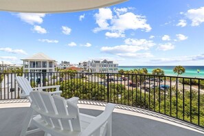 A balcony with white chairs, a view of the ocean, and a building in the background. - 30A | Rooftop Pool | Gulf Views | 2 Min To Beach! (Santa Rosa Beach)