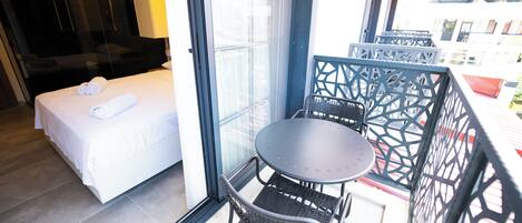 A hotel room with a bed, a small table, and a chair.