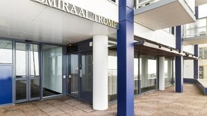 Une entrée moderne avec des portes en verre et une enseigne indiquant « OMIRAAL TROMP ».