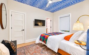 A bedroom with a bed, a TV, a lamp, and a patterned ceiling. - Chic Nash Home, 4bd/4ba w/ Hot Tub & Rooftop! (Nashville)