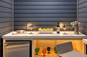 A modern kitchen counter with a bowl of lemons, a wine bottle, and glasses. - Chic Nash Home, 4bd/4ba w/ Hot Tub & Rooftop! (Nashville)
