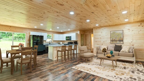 A spacious living area with a wooden floor, a dining set, a sofa, and a kitchen with white cabinets. - Black Butte - Lux Family Cabin With Games Firepit (Sevierville)