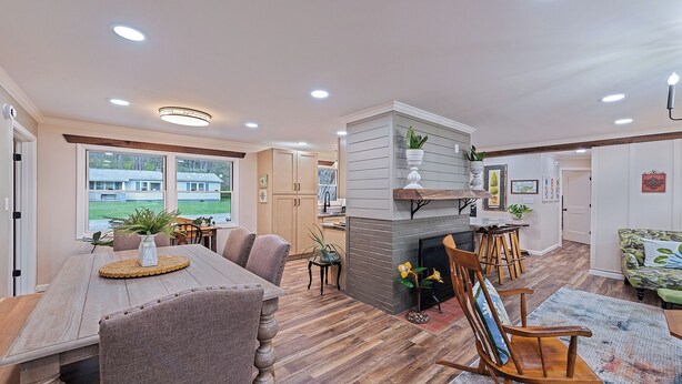A spacious living room with a fireplace, dining area, and kitchen.