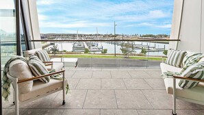 Un balcón con dos sofás y vistas a un puerto deportivo.