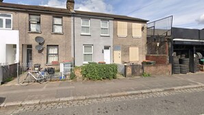 A residential street with houses, a bicycle, and a tire shop. - Stylish East London Stay | 2-Bed in Forest Gate (Greater London)
