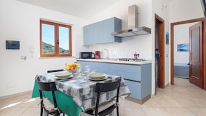 Una cucina compatta con zona pranzo, una finestra vista e un piccolo bancone con forno a microonde e bollitore.