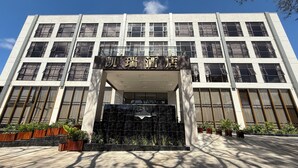 A modern building with a large entrance, multiple windows, and a sign above the entrance. - CARREY HOTEL- Accommodation BB-MICE (Lusaka)