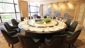 A round dining table with eight chairs, set for a meal. - CARREY HOTEL- Accommodation BB-MICE (Lusaka)