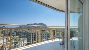 A balcony with a city view, a table, and chairs. - Kleopatra Carmen Apart (Alanya)