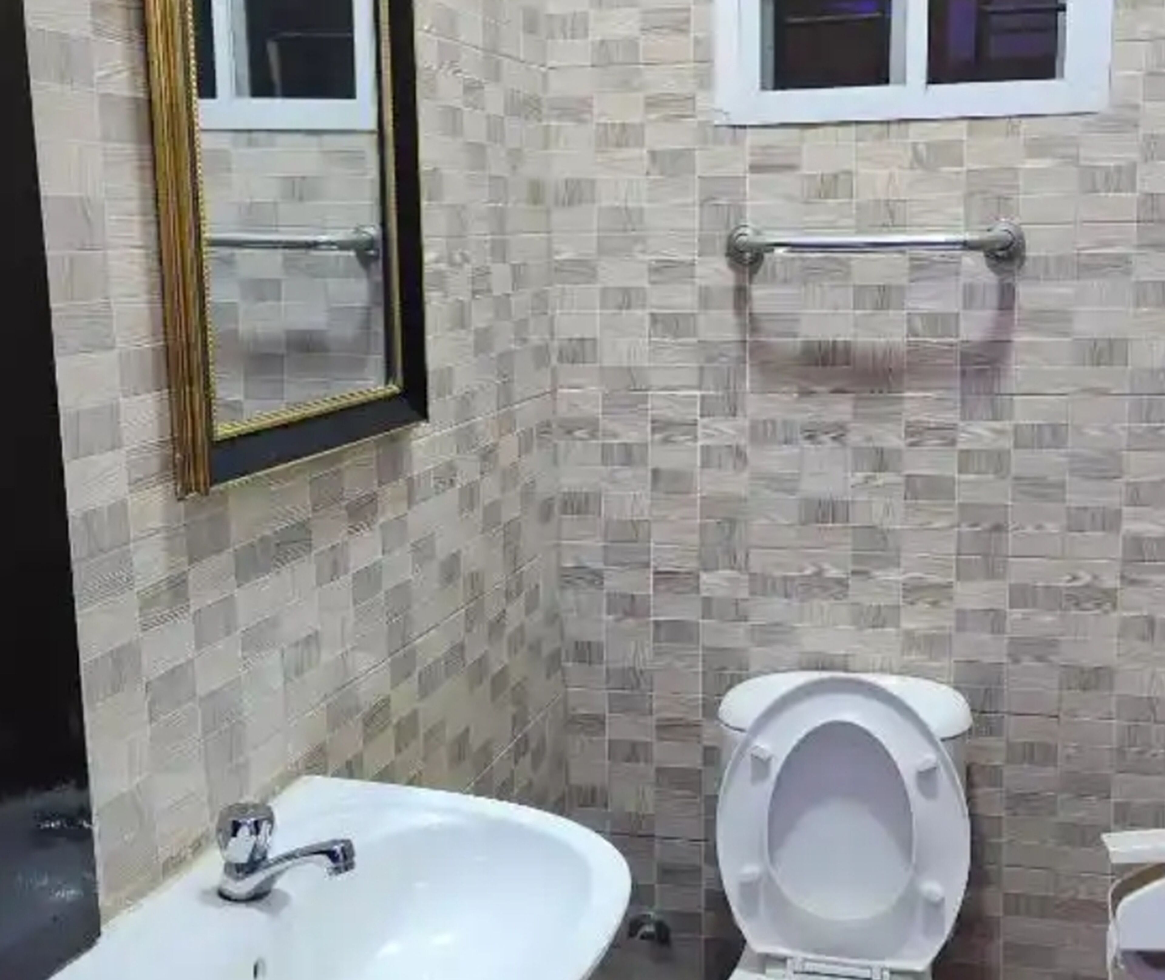 Un baño con un lavabo blanco, un inodoro y un espejo.