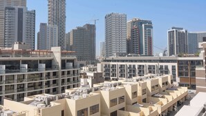 A modern urban residential area with high-rise buildings, some under construction, and a mix of architectural styles. - StayShort - Stylish Modern Studio in Living Garden 2 (JVC)