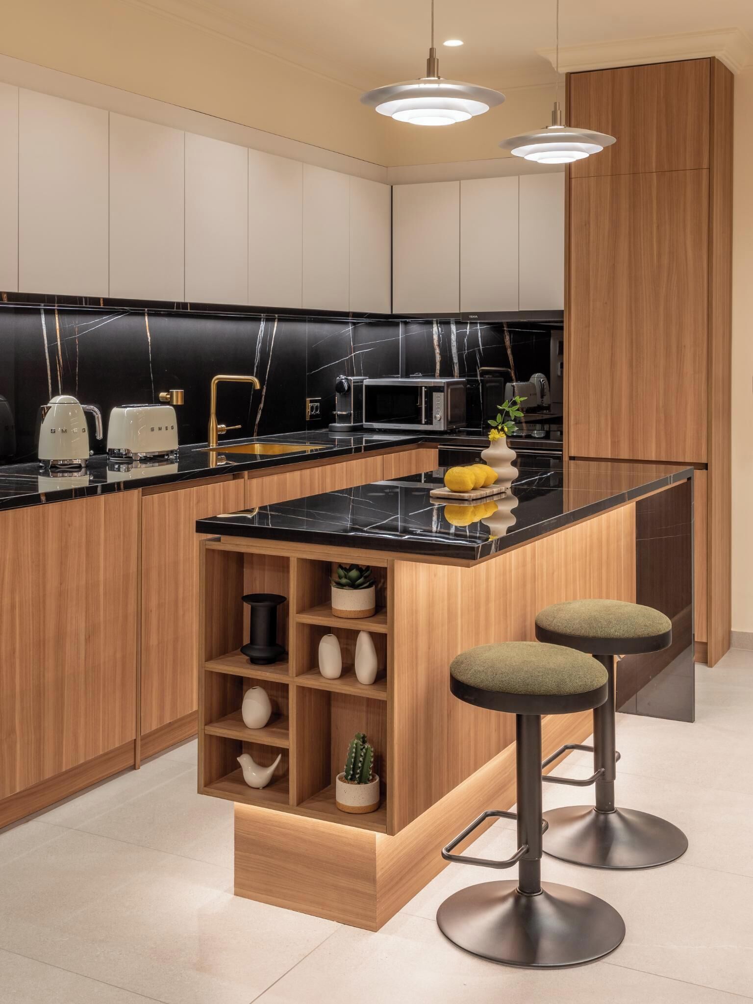 A modern kitchen with black marble countertops, wooden cabinets, and a central island with stools.