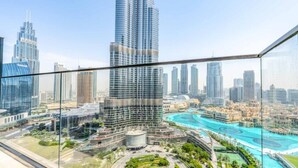 A high-rise building with a modern glass facade, surrounded by other skyscrapers and a waterfront area with a circular park and a pool. - Creston Suites Vacation Homes Rental - Address Opera Residences (Dubai)