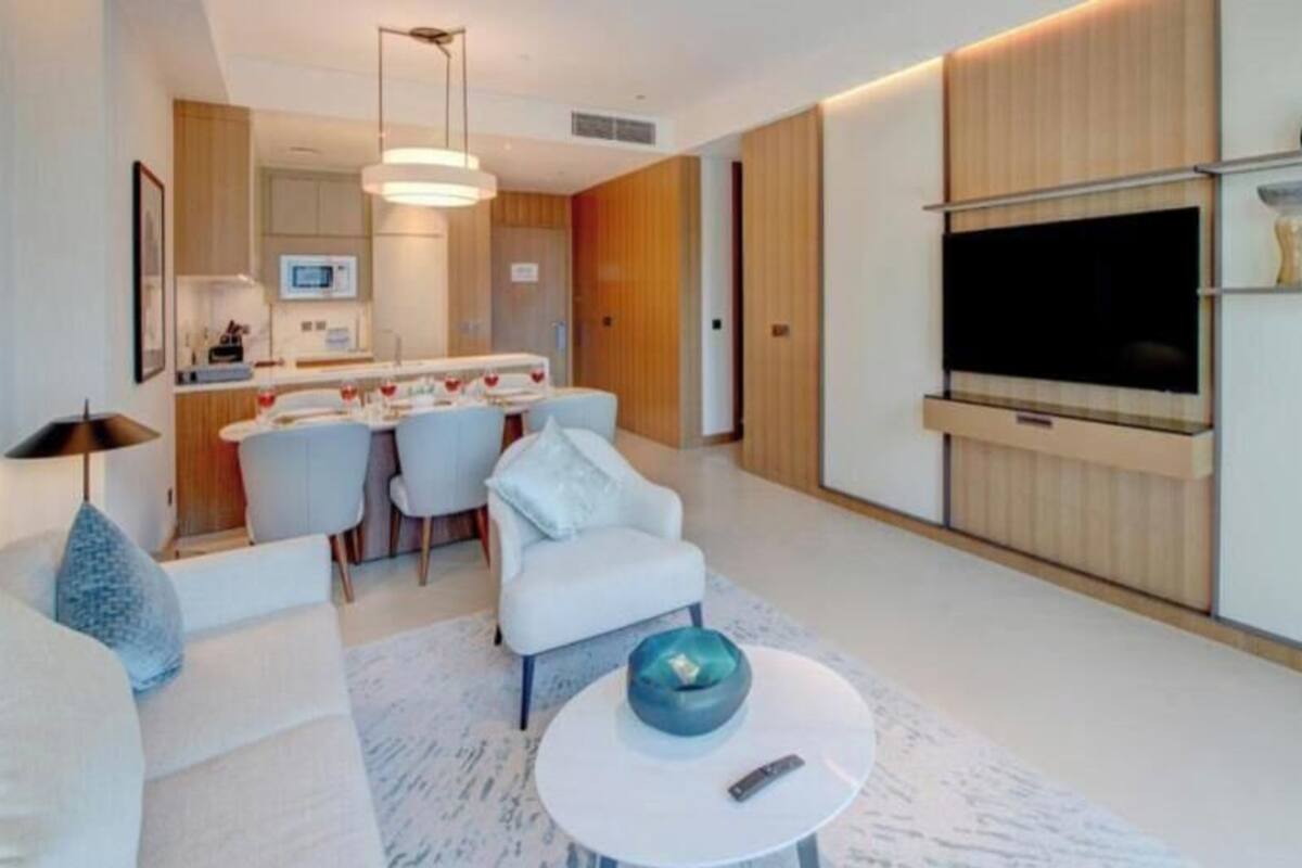 A modern living room with a sofa, a coffee table, and a dining area with chairs.