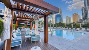 A rooftop pool area with lounge chairs and umbrellas, surrounded by modern buildings. - Creston Suites Vacation Homes Rental - Address Opera Residences (Dubai)
