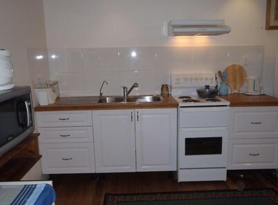 Open-plan living, ground level of two-storey house with sugar cane & rural views