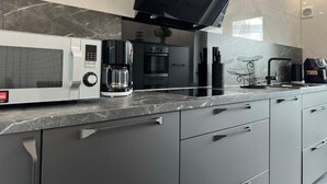 Una cucina moderna con microonde, macchina del caffè e forno integrato.