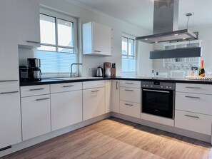Enjoy cooking in this well-equipped kitchen with an oven and stainless steel range hood.