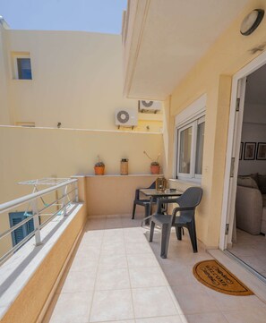 Enjoy a peaceful retreat on this balcony with a table for two, a potted plant, and a decorative accent.