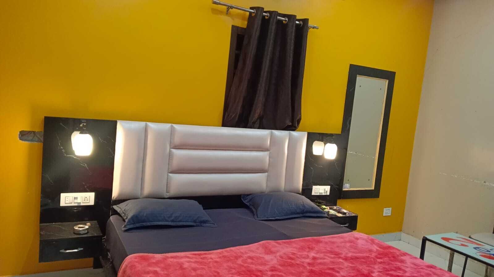 Un letto con testiera, due cuscini, un comodino e uno specchio a parete.