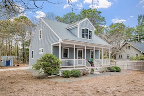A two-story house with a porch, a small shed, and a fenced yard.