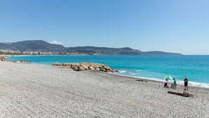 A pebble beach with a rocky outcrop and a clear blue sea. - HappyFew Palazzo Suite (Nice)