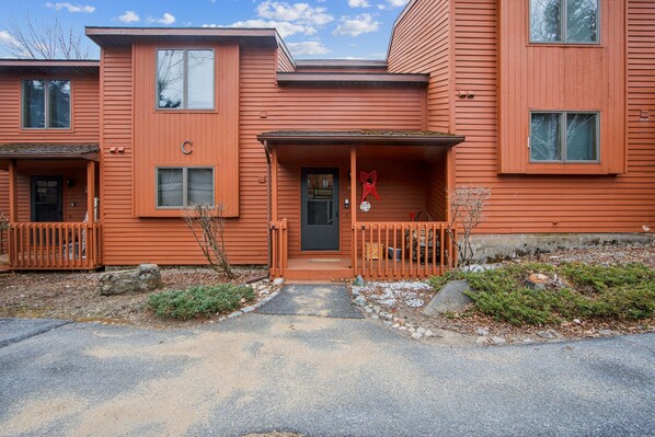 A two-story building with a porch and a door. - Wood Lot 28C - Retreat Near Recreation Center 2 Bedroom Townhouse by The Summit at Gore Mountain (North Creek)