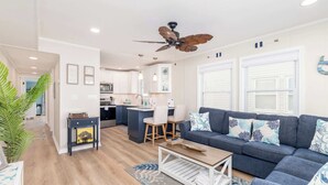 Ein modernes Wohnzimmer mit einer Couch, einem Couchtisch und einem Deckenventilator.