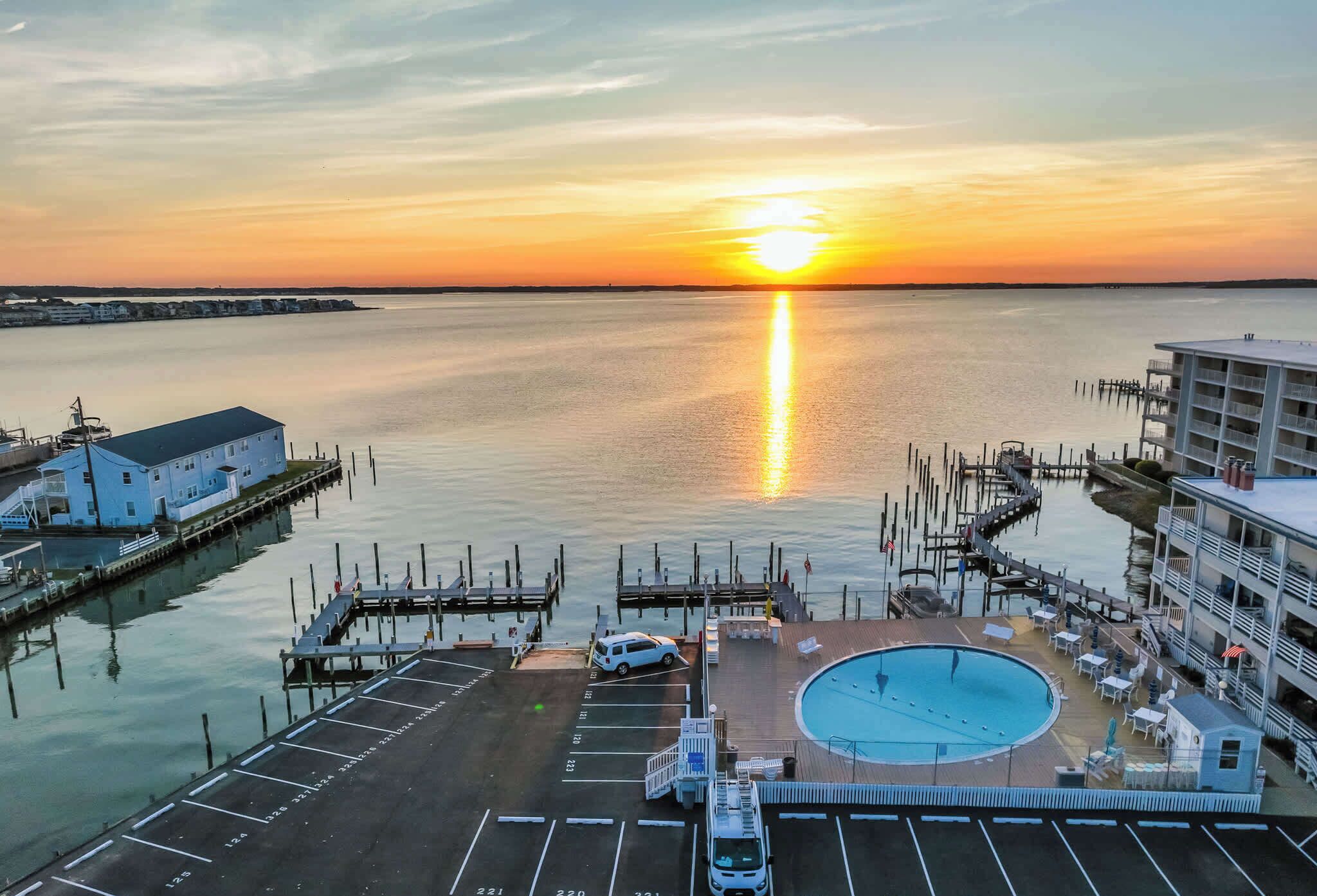 A marina with a swimming pool, docked boats, and a building with balconies.