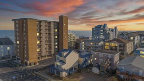 Una zona residencial costera con edificios de varios pisos, incluyendo una estructura de ladrillo destacada y varias otras viviendas.